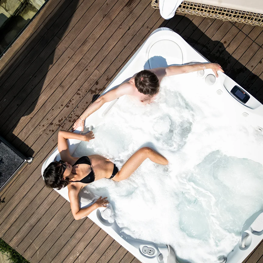 Vedere de sus asupra unui cuplu care se relaxează în jacuzziul de pe terasa Eden Hill.