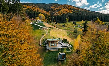 Aerial view of Eden Hill villas among green lawns and trees in autumn colours.